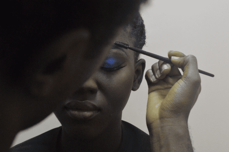 A woman getting her eye makeup by eye lashes extensions