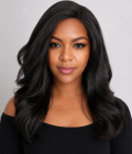 Black woman wearing a synthetic kinky straight glueless wig with soft natural texture and Swiss lace front against a clean studio background.